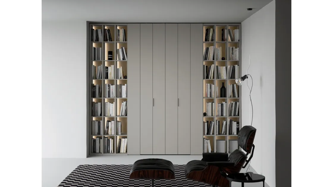 Libreria a giorno lineare e geometrica, in laccato opaco, arricchita dalla schiena in laccato metallico Oxid e impreziosita dall’illuminazione a led passaggio porta di Caccaro